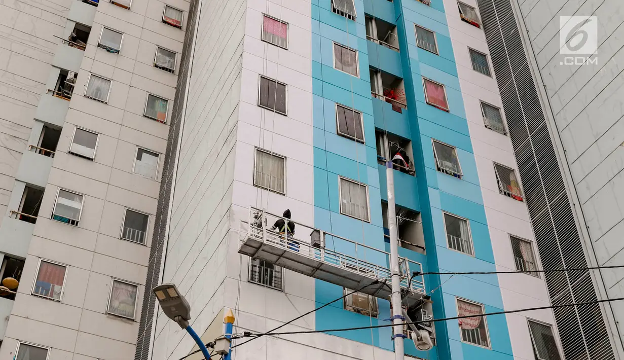 Pekerja mengecat dinding Rusun Jatinegara Barat di Jakarta, Selasa (18/9). Pengecatan dilakukan untuk memercantik bangunan rusun serta mencegah dinding agar tidak kusam. (Liputan6.com/Immanuel Antonius)