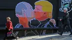 Warga melewati mural bergambar calon Presiden AS, Donald Trump dan Presiden Rusia, Vladimir Putin sedang berciuman di Vilnius, (13/5). Mural ini dibuat sebagai sindiran terhadap Donald Trump dan Vladimir Putin. (AFP PHOTO/Petras Malukas)