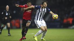 Gelandang Manchester United (MU), Marcus Rashford, berebut bola dengan bek West Bromwich Albion (WBA), Ahmed Hegazi, pada laga Premier League di Stadion The Hawthorns, Minggu (17/12/2017). MU menang 2-1 atas WBA. (AP/Nick Potts)