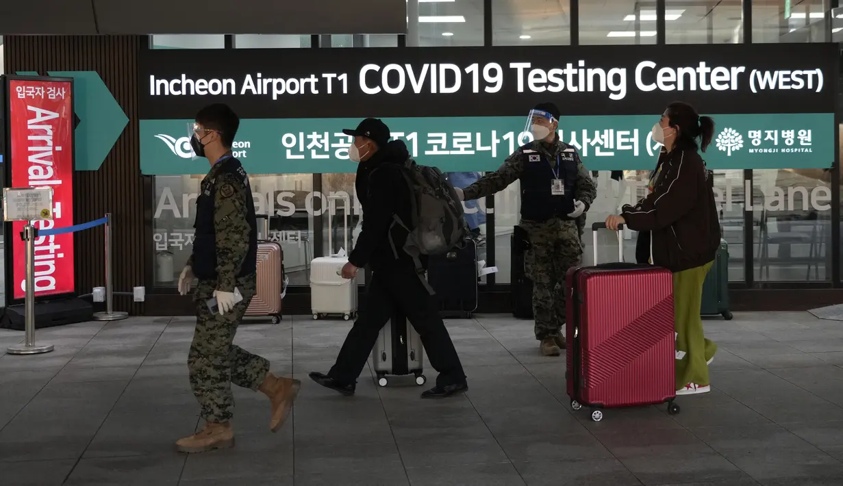 Penumpang yang tiba dari China melewati pusat pengujian COVID-19 di Bandara Internasional Incheon di Incheon, Selasa (10/1/2023). China menangguhkan visa pada Selasa bagi warga Korea Selatan yang datang ke negara itu untuk pariwisata atau bisnis sebagai pembalasan yang nyata untuk persyaratan pengujian COVID-19 pada pelancong China. (AP Photo/Ahn Young-joon)