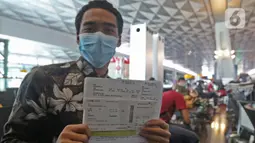 Calon penumpang dengan izin khusus kembali ke daerah asal usai pendidikan di Arab Saudi menunjukan surat syarat terbang di Terminal 3 Bandara Soekarno Hatta, Tangerang, Kamis (7/5/2020). Pemerintah membuka kembali penerbangan domestik dengan penumpang bersyarat. (Liputan6.com/Herman Zakharia)