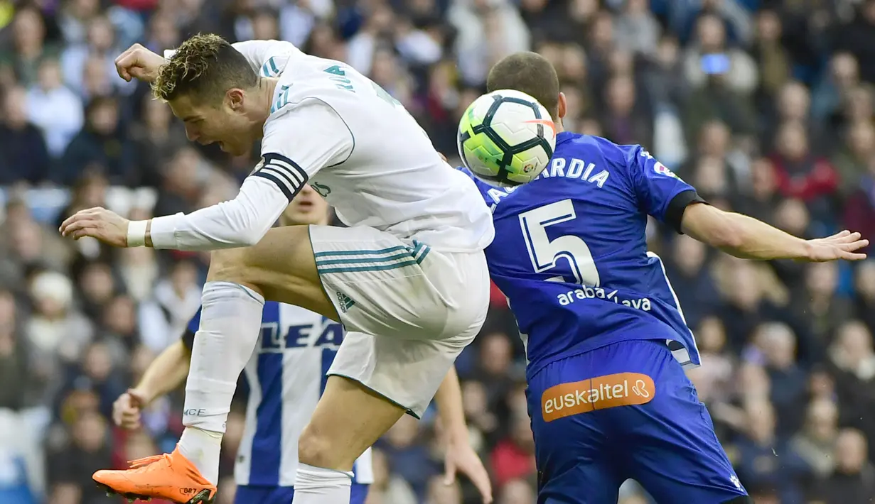 Aksi pemain Real Madrid, Cristiano Ronaldo (kiri) saat berebut bola dengan pemain Alaves, Victor Laguardia Cisneros (kanan) pada La Liga Santander di Santiago Bernabeu stadium, Madrid, (24/2/2018). Real Madrid menang 4-0. (AFP/ Pierre-Philippe Marcou)