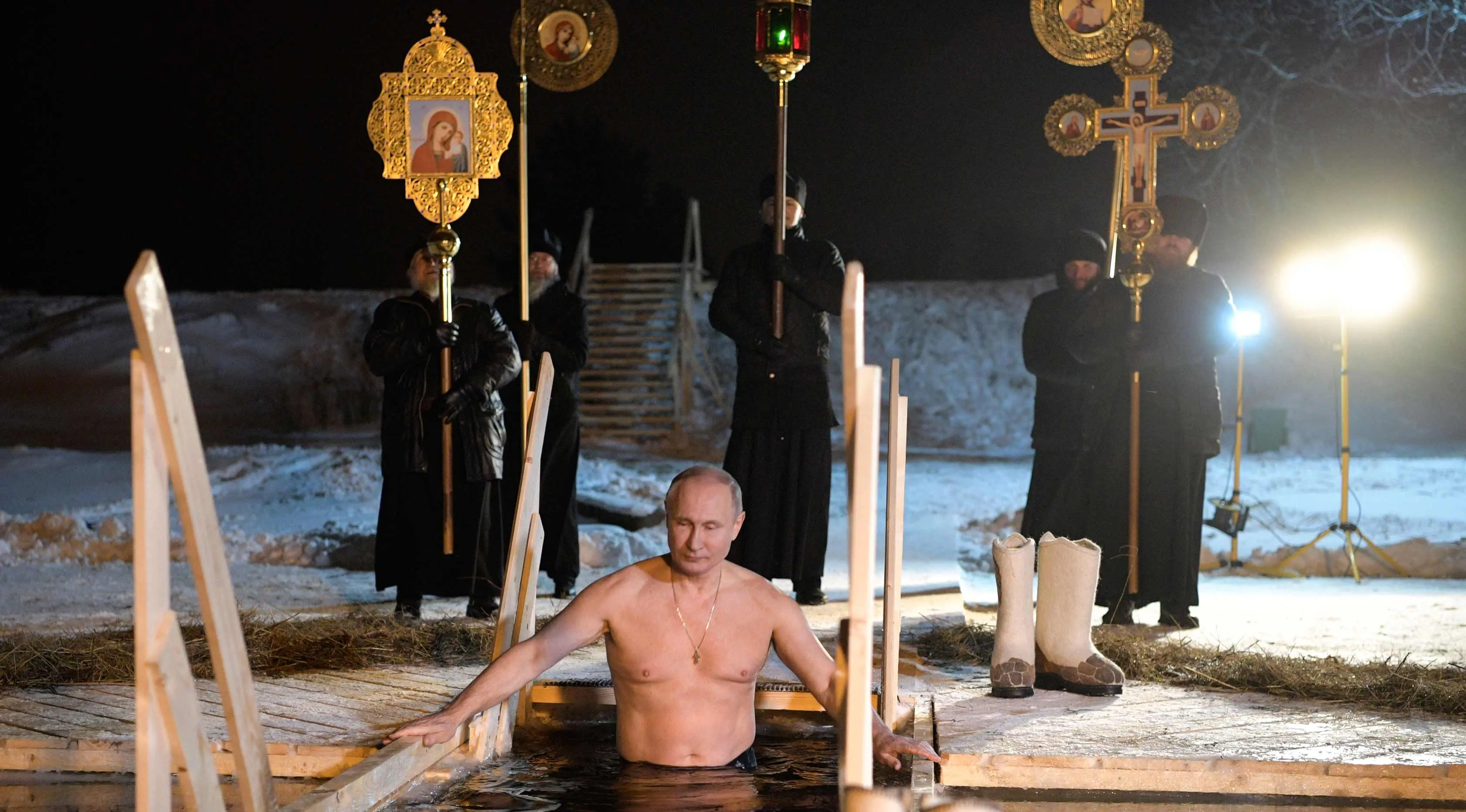 Presiden Rusia Vladimir Putin berendam di air dingin di Danau Seliger di desa Svetlitsa, Rusia (19/1). Ribuan pengikut Gereja Ortodoks Rusia akan berendam ke sungai dan kolam es merayakan Epiphany. (Alexei Druzhinin, Sputnik, Kremlin Pool Photo via AP)