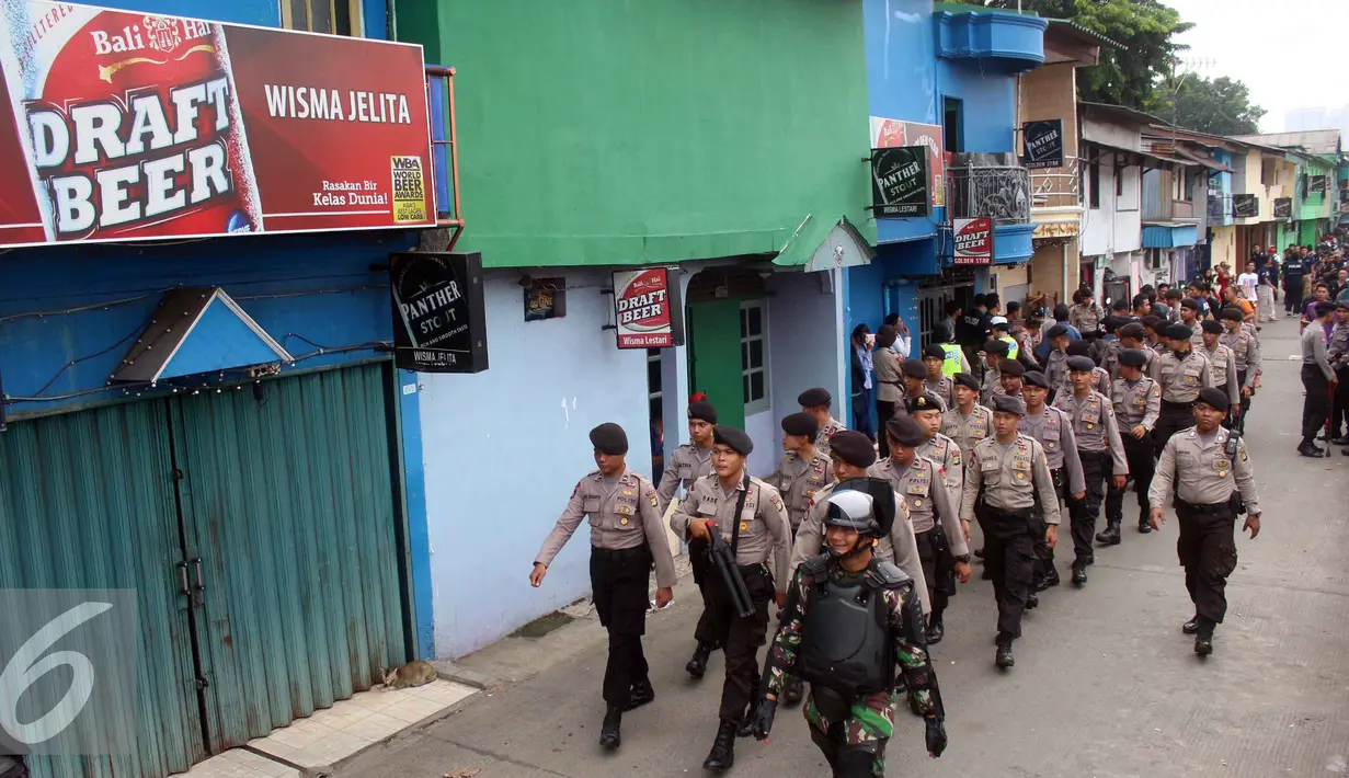 Petugas kepolisian saat melakukan operasi Pekat di kawasan Kalijodo, Jakarta Utara, Sabtu (20/2). Operasi ini bukanlah dalam rangka penggusuran yang direncanakan oleh Pemprov DKI Jakarta. (Liputan6.com/Faizal Fanani)