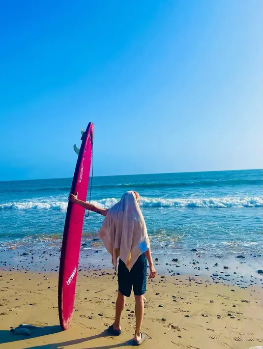 Unggahan lain yang dibagikan Taeyong adalah saat ia berada di pantai. Ia bersandar dengan sebuah papan selancar, menghadap birunya langit dan laut yang membentang. (Foto: Instagram/ taeoxo_nct)