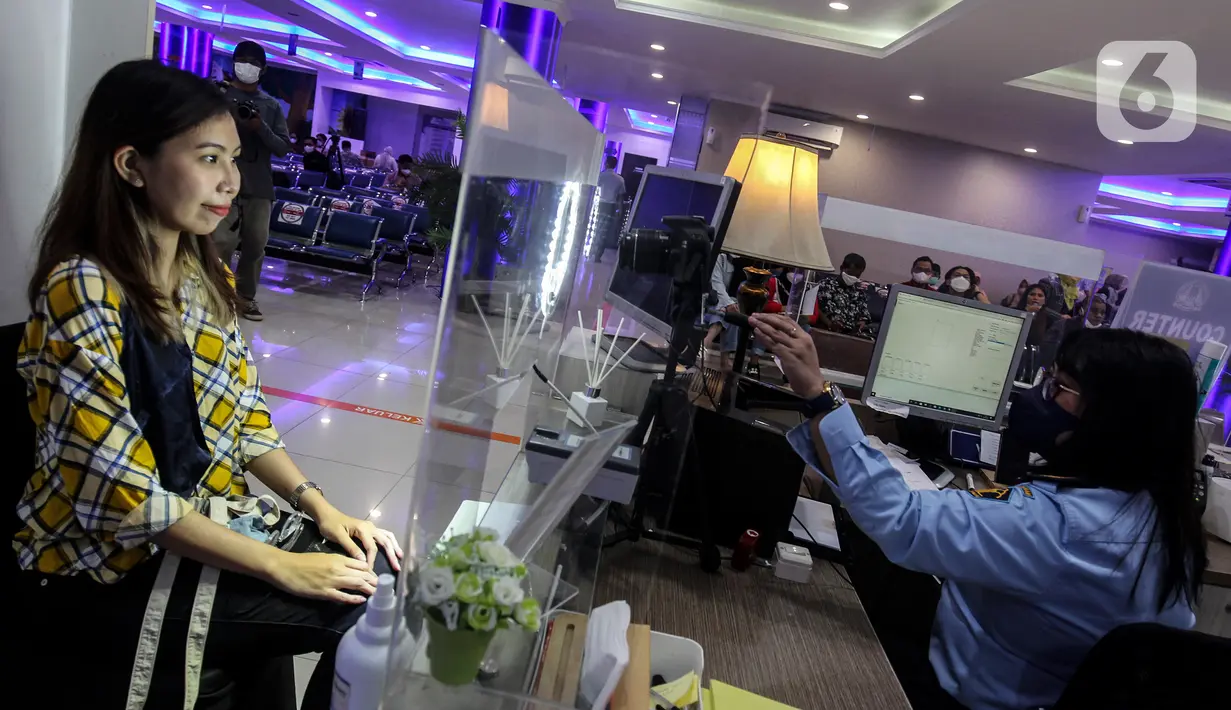 Petugas melakukan perekaman data pemohon pembuatan paspor Republik Indonesia (RI) di Kantor Imigrasi Kelas 1 Non TPI Jakarta Timur, Jakarta, Jumat (14/10/2022). Sesuai Peraturan Menteri Hukum dan HAM RI Nomor 18/2022 mulai 12 Oktober 2022 masa berlaku paspor biasa paling lama 10 tahun untuk semua jenis permohonan yang telah berusia 17 tahun atau sudah menikah. (Liputan6.com/Johan Tallo)