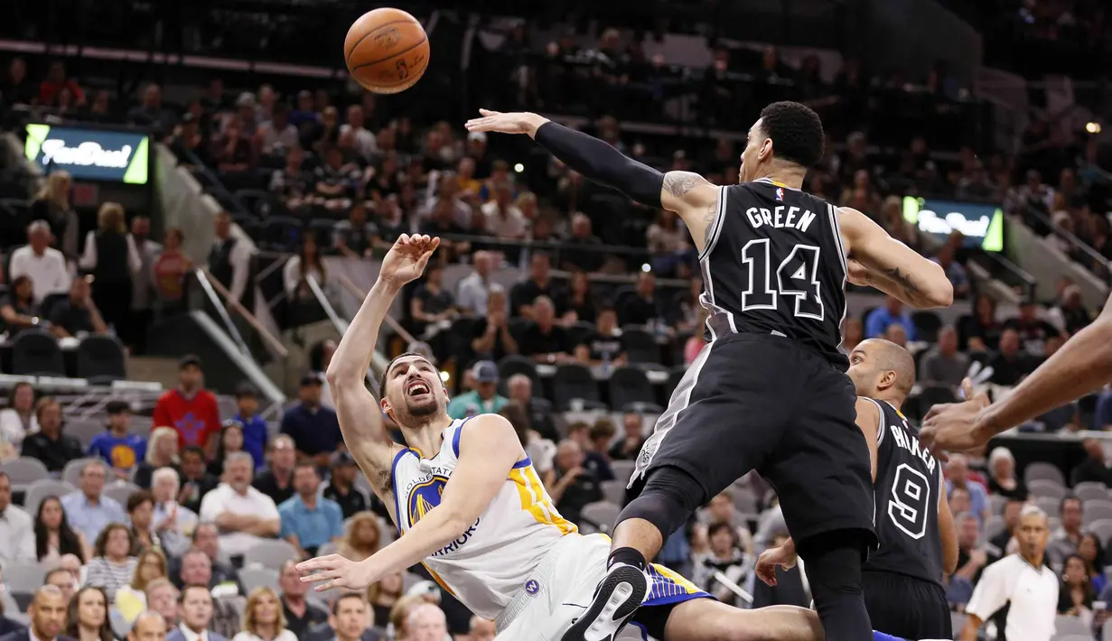 Pemain Golden State Warriors, Klay Thompson (kiri), melakukan tembakan melewati hadangan pemain San Antonio Spurs, Danny Green (14), pada lanjutan NBA di AT&T Center, San Antonio, AS, (10/4/2016). (Reuters/Soobum Im-USA Today Sports)