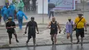 Penonton berjalan saat hujan lebat yang menyebabkan penundaan Race 1 World Superbike (WSBK) di Pertamina Mandalika International Street Circuit, Lombok Tengah, Nusa Tenggara Barat, Sabtu (20/11/2021). Hujan deras memaksa Race 1 WSBK Mandalika ditunda pada 21 November. (BAY ISMOYO/AFP)