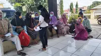 Nasabah KSP Syariah Logam Mulia duduk-duduk di teras kantor Polsek Brati, Grobogan untuk mengadukan permasalahan tabungan dan deposit. (Foto: Liputan6.com/Felek Wahyu)