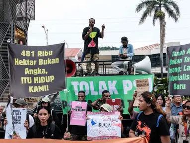 Para pengunjuk rasa menggelar aksi menentang rencana pemerintah untuk melepaskan kawasan hutan di Papua Selatan bagi proyek-proyek strategis nasional di bidang pangan, energi, dan pertahanan di depan Kantor Menteri Agraria dan Tata Ruang/Kepala Badan Pertanahan Nasional (ATR/BPN), Selasa (7/10/2025). (Yasuyoshi CHIBA/AFP)