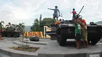 Anak-anak berswafoto dengan tank tempur bersejarah TNI yang berada di Monumen Nani Wartabone di Kilometer Nol Kota Gorontalo, Sabtu (22/9). Tank dipajang di Lapangan Taruna Remaja berdampingan dengan patung Nani Wartabone. (Liputan6.com/Arfandi Ibrahim)