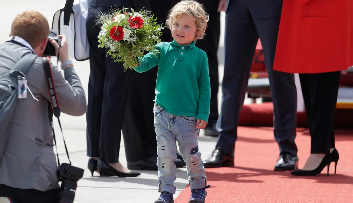 Putra PM Kanada Justin Trudeau, Hadrien, mengarahkan buket bunga kepada fotografer setibanya di Hamburg, Jerman, Kamis (6/7). PM Kanada membawa istri, Sophie Gregoire-Trudeau, dan putranya, Hadrien untuk menghadiri KTT G20. (AP Photo/Markus Schreiber)