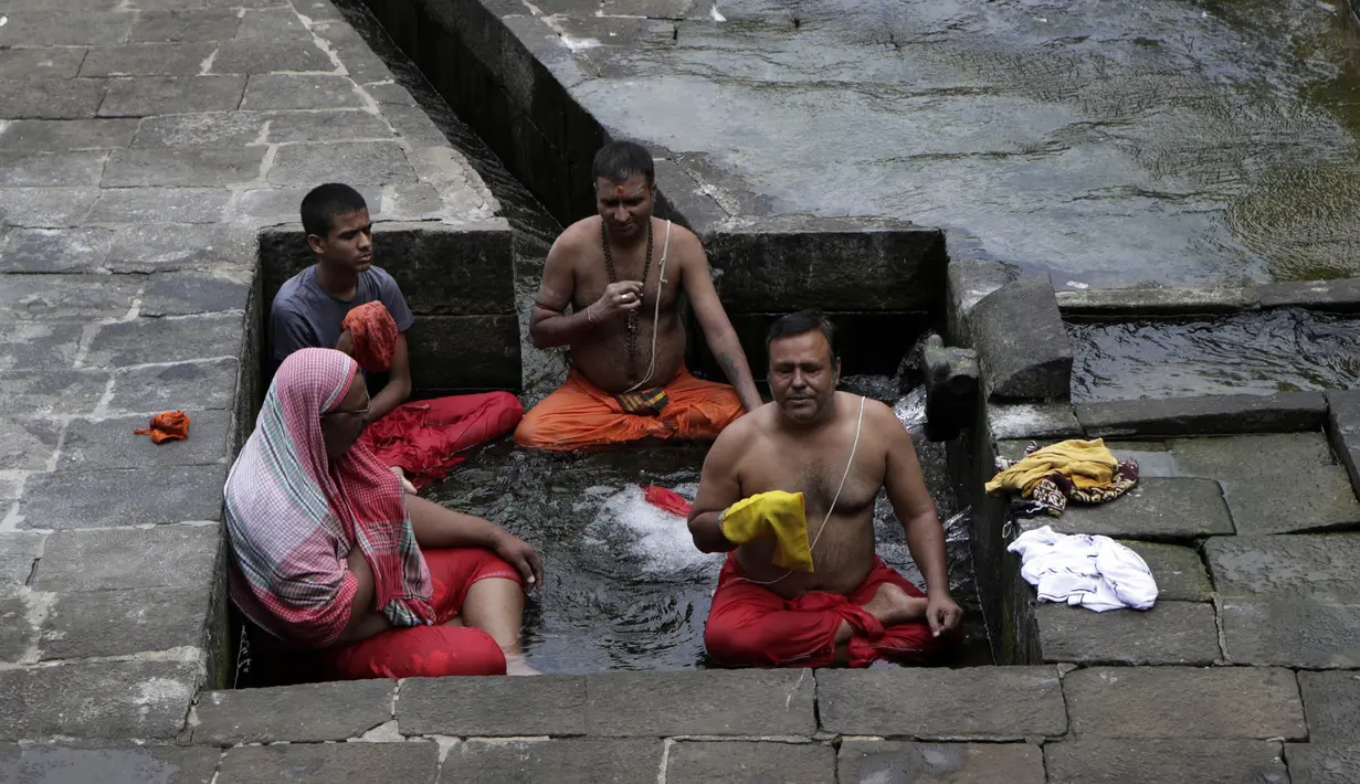 Umat Hindu melakukan ritual selama gerhana matahari di Banganga, Mumbai, India, Minggu (21/6/2020). Fenomena gerhana matahari pada 21 Juni 2020 terlihat dari berbagai negara di dunia. (AP Photo/Rajanish Kakade)