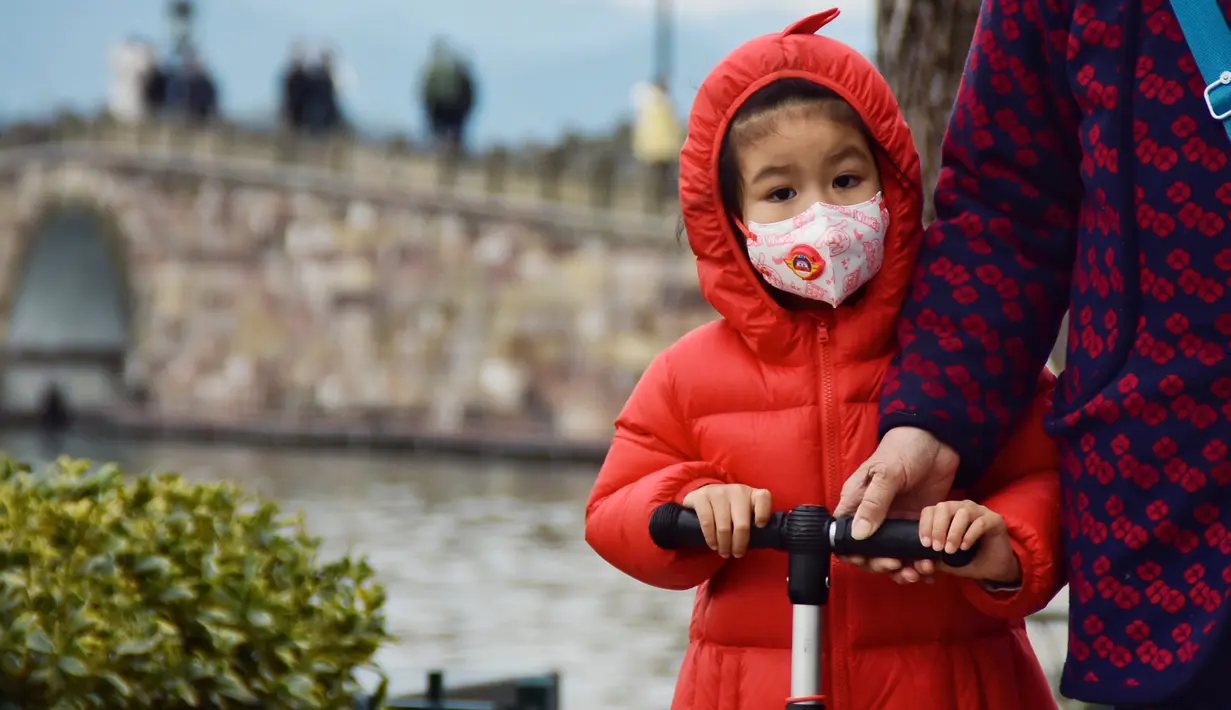 Seorang anak saat mengunjungi kawasan Danau Barat yang indah di Hangzhou, Provinsi Zhejiang, China timur (19/2/2020). Taman-taman dan objek wisata yang tergabung dalam kawasan Danau Barat telah dibuka kembali secara teratur pada Rabu (19/2). (Xinhua/Zheng Mengyu)