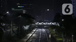 Warga menyeberang saat diberlakukannya Car Free Night dan Crowd Free Night di Jalan Sudirman-MH Thamrin, Jakarta (31/12/2020). Jalan Sudirman-MH Thamrin ditutup pada malam pergantian tahun untuk mencegah kerumunan warga. (Liputan6.com/Johan Tallo)