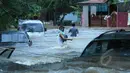 Warga Perumahan Ciledug Indah 1, Tangerang, menyeberangi banjir menggunakan tali untuk menghindari arus deras, Selasa (10/2/2015).(Liputan6.com/Andrian M Tunay)