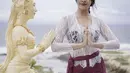 Anya terlihat anggun mengenakan kebaya khas Bali yang berwarna putih dipadukan dengan selendang yang diikat seperti sabuk dengan bawahan kain berwarna magenta. Instagram @anyageraldine