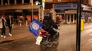 Suporter Leicester City membawa bendera sambil mengendarai motornya usai timnya meraih juara Liga Inggris di depan rumah Jamie Vardy, Leicester, (3/5). Leicester Juara setelah saingannya Tottenham bermain imbang 2-2 dengan Chelsea. (Reuters/Eddie Keogh)