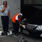 Petugas memasang pelat mobil baru di mobil dinas Menteri Perhubungan yang baru di Kemenhub, Jakarta, (27/10/2014). (Liputan6.com/Faizal Fanani) 