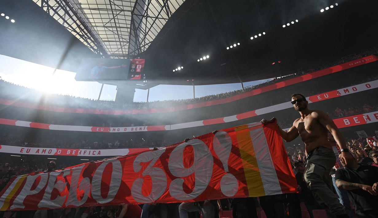 Para pendukung Benfica membentangkan banner dalam laga lanjutan Liga Portugal 2024/2025 melawan Sporting di Stadion da Luz, Lisbon, Portugal, Sabtu (10/05/2025) waktu setempat. (AFP/Patricia De Melo Moreira)