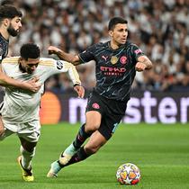 Gelandang Man City, Rodri (kanan) ketika merebut bola dari gelandang Real Madrid, Jude Bellingham, dalam leg pertama perempat final Liga Champions 2023/2024 di Santiago Bernabeu, Rabu (10/4/2024) dini hari WIB. (JAVIER SORIANO / AFP)