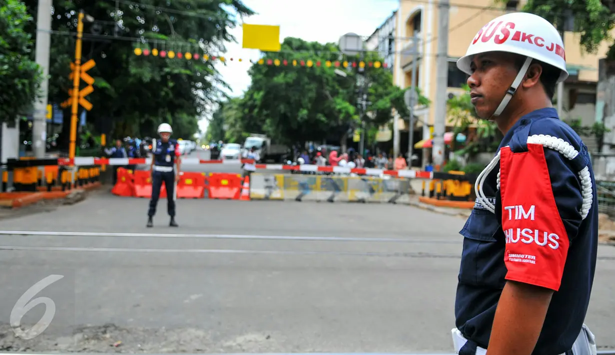 Petugas PT KAI berjaga di perlintasan kereta api Stasiun Tebet, Jakarta, Kamis (7/4). Dishubtrans DKI melakukan uji coba penutupandan pengalihan arus lalu lintas di bawah flyover Tebet tepat depan Stasiun Tebet. (Liputan6.com/Yoppy Renato)