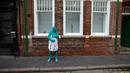 Seorang model memakai kardus menutupi tubuhnya usai mengikuti sesi foto menjadi model sebuah seni berjudul "Sea of Hull" karya Spencer Tunick asal Amerika Serikat di pusat Kota Hull, Inggris, Sabtu (9/7). (AFP Photo/Jon Super)