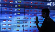 Karyawan berjalan di depan layar Indeks Harga Saham Gabungan (IHSG) di Bursa Efek Indonesia, Jakarta, Jumat (22/1/2021). Indeks acuan bursa nasional tersebut turun 96 poin atau 1,5 persen ke 6.317,864. (Liputan6.com/Johan Tallo)