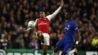 Pemain Arsenal, Alex Iwobi (kiri) menghalau bola dari kejaran pemain Chelsea, Antonio Rudiger pada laga leg pertama semifinal Piala Liga Inggris di Stamford Bridge, London, (10/01/2018). Chelsea bermain imbang 0-0 lawan Arsenal. (AFP/Adrian Dennis)