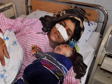 Reza Gul (20) bersama bayinya menjalani perawatan di rumah sakit di Provinsi Faryab, Afghanistan, 19 Januari 2016. Wanita yang telah enam tahun menikah itu mengalami cacat fisik setelah sang suami memotong hidungnya dengan pisau. (AFP PHOTO/Hasan Sirdash)
