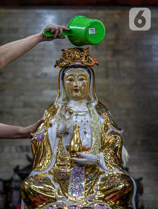 Seorang jemaat membersihkan patung yang ada di Vihara Amurva Bhumi, Jakarta, Kamis (4/2/2021). Ritual mencuci patung dewa serta bersih-bersih ini dilakukan dalam rangka menyambut perayaan Tahun Baru Imlek 2572. (Liputan6.com/Faizal Fanani)
