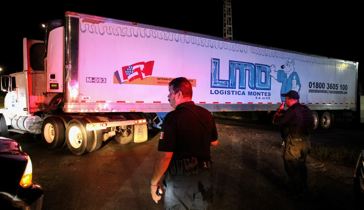Sebuah kontainer truk trailer berisi lebih dari 100 dipindahkan dari Guadalajara menuju Jalisco di Meksiko, Senin (17/9). Mayat-mayat tersebut tidak bisa diserahkan kepada keluarganya karena belum diketahui identitasnya. (AFP/Ulises Ruiz)