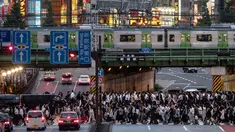 Pejalan kaki menyeberangi jalan raya saat kereta Yamanote Line melintas pada jam sibuk di Distrik Shinjuku, Tokyo, Jepang, Selasa (4/6/2019). Yamanote loop line menawarkan wisatawan untuk melihat kehidupan sehari-hari warga di pusat Kota Tokyo. (AP Photo/Jae C. Hong)