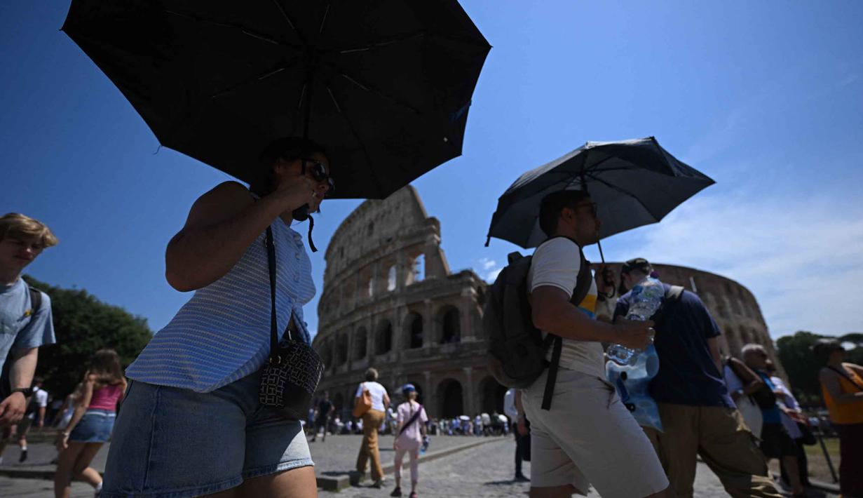 Orang-orang melindungi diri dari terik matahari dengan payung di dekat Koloseum selama gelombang panas awal musim di Roma pada Kamis 28 Mei 2026. (Tiziana FABI/AFP)