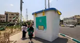 Orang-orang berjalan melewati replika kotak suara yang dipasang di sebuah jalan di Teheran pada 20 Juni 2024. (Atta KENARE/AFP)