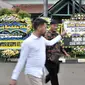 Pelayat melintasi karangan bunga duka cita untuk mendiang Eka Tjipta Widjaja di depan Rumah Duka Sentosa RSPAD Gatot Soebroto, Jakarta, Minggu (27/1). Pendiri Sinar Mas Group tersebut meninggal dunia pada 26 Januari 2019. (Merdeka.com/Iqbal Nugroho)