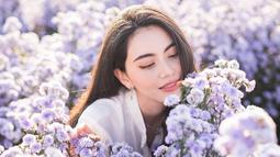 Davika Hoorne terlihat begitu menawan saat berada di antara bunga-bunga dengan kelopak kombinasi ungu dan putih. Gaya penampilan Davika ini banjir pujian dari netizen yang menyebutnya kian memesona. (Liputan6.com/IG/@davikah)