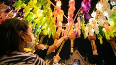 Orang-orang menggantung lampion di Wat Phra That Hariphunchai, Lamphun, Thailand, 1 November 2020. Sekitar 100.000 lampion digantung di Wat Phra That Hariphunchai sebagai bagian dari perayaan festival tradisional Yi Peng. (Xinhua/Zhang Keren)