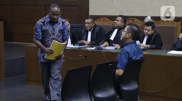 Mantan Kadis PU Papua, Mikael Kambuaya (kiri) dan Komisaris PT Manbers Jaya Mandiri, David Manibui saat sidang dakwaan di Pengadilan Tipikor Jakarta, Rabu (20/11/2019). Keduanya didakwa dalam kasus dugaan suap pekerjaan peningkatan jalan Kemiri-Depapre TA 2015. (Liputan6.com/Helmi Fithriansyah)