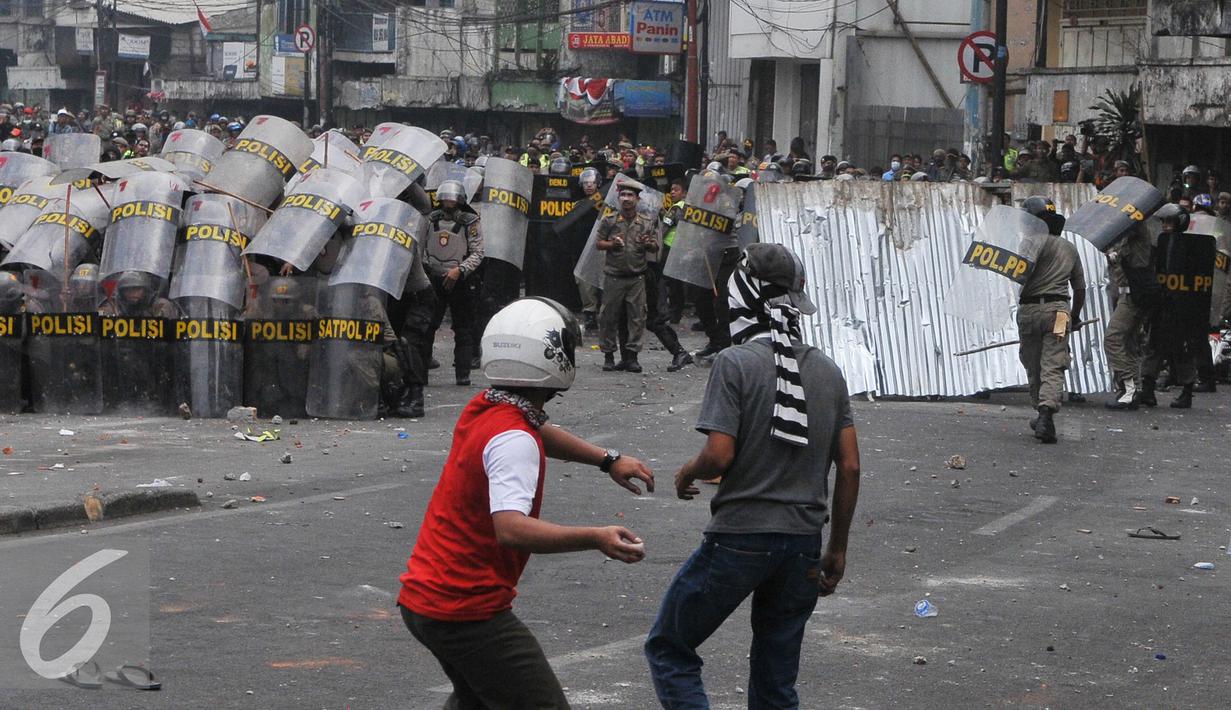 Warga Kampung Pulo menyerang Petugas saat penggusuran Kampung Pulo, Jakarta, Kamis (20/8/2015). Penggusuran pemukiman Kampung Pulo dilakukan oleh 2.200 personel gabungan untuk normalisasi Sungai Ciliwung. (Liputan6.com/Herman Zakharia)