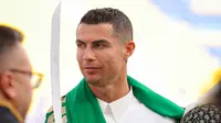 Pemain Al-Nassr, Cristiano Ronaldo memakai gamis dan membawa pedang saat memperingati Hari Pendirian Kerajaan Saudi atau Founding Day di tempat berlatih pada Rabu (22/02/2023). (Twitter/@AlNassrFC)