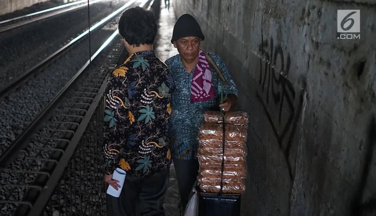 Pejalan kaki melintasi jalan setapak di sekitar Stasiun Cawang, Jakarta, Kamis (9/5). Meskipun sempit, jalan setapak tersebut masih menjadi pilihan sebagian pejalan kaki untuk menyeberangi Jalan Gatot Soebroto, dibanding harus melewati JPO yang jaraknya lebih jauh. (Liputan6.com/Immanuel Antonius)