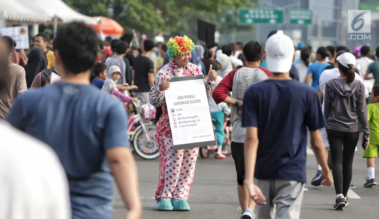Satgas saber pungli mengenakan kostum badut mensosialisasikan tolak pungli di Car Free Day, Jakarta, Minggu (12/11). Satgas saber juga gencar melakukan sosialisasi adanya tim khusus untuk menindak tindakan pungli. (Liputan6.com/Faizal Fanani)