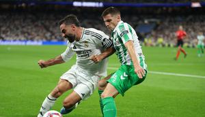 Bek Real Madrid asal Spanyol, Dani Carvajal, berebut bola dengan bek Real Betis asal Prancis, Romain Perraud, selama pertandingan sepak bola liga Spanyol antara Real Madrid CF dan Real Betis di stadion Santiago Bernabeu, Madrid, pada 1 September 2024.Thomas COEX / AFP