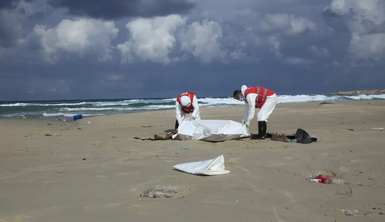 Kelompok Bulan Sabit Merah Libya memasukkan jenazah yang diduga imigran yang tewas tenggelam, ke kantong mayat di pantai Khoms, sebelah timur Tripoli, Minggu (25/10). Sedikitnya 40 jasad telah ditemukan di pantai Libya. (REUTERS/Ismail Zitouny)