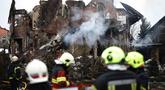 Para petugas penyelamat Ukraina berdiri di samping sebuah rumah yang rusak parah setelah serangan udara di Sofiivska Borshchagivka, wilayah Kyiv pada Minggu 22 Februari 2026. Rusia kembali melancarkan serangan besar-besaran menggunakan rudal dan pesawat nirawak (drone) ke wilayah pinggiran kota Kyiv. (Henry NICHOLLS/AFP)