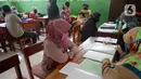 Wali murid siswa Sekolah SD kelas 4,5 dan 6 sedang mengambil rapot secara bergilir di Sekolah Islam Raudlatul Hikmah, Parakan, Pondok Benda, Pamulang, Tangerang Selatan, Banten, Jumat (16/10/2020). (merdeka.com/Dwi Narwoko)