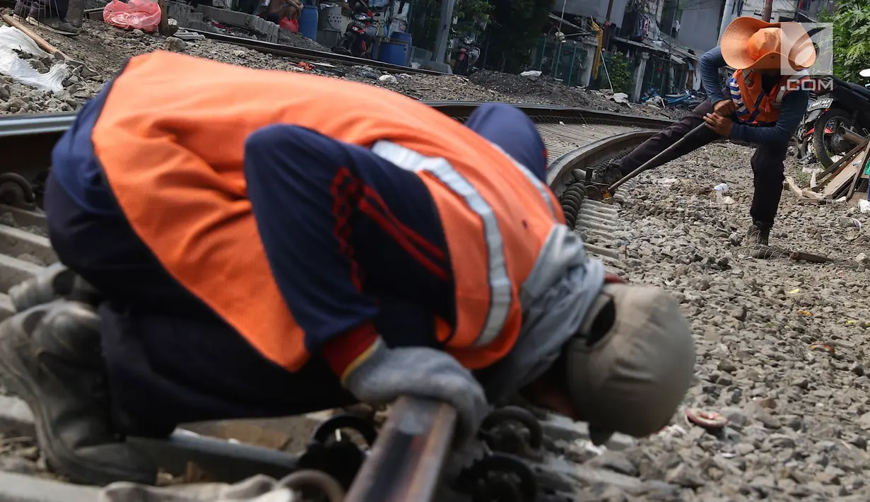 Pekerja mengukur bantalan rel kereta di kawasan Roxy, Jakarta, Selasa (7/1). Penambahan kerikil tersebut dilakukan sebagai bentuk perawatan rutin agar perjalanan kereta tetap aman dan lancar. (Liputan6.com/Immanuel Antonius)