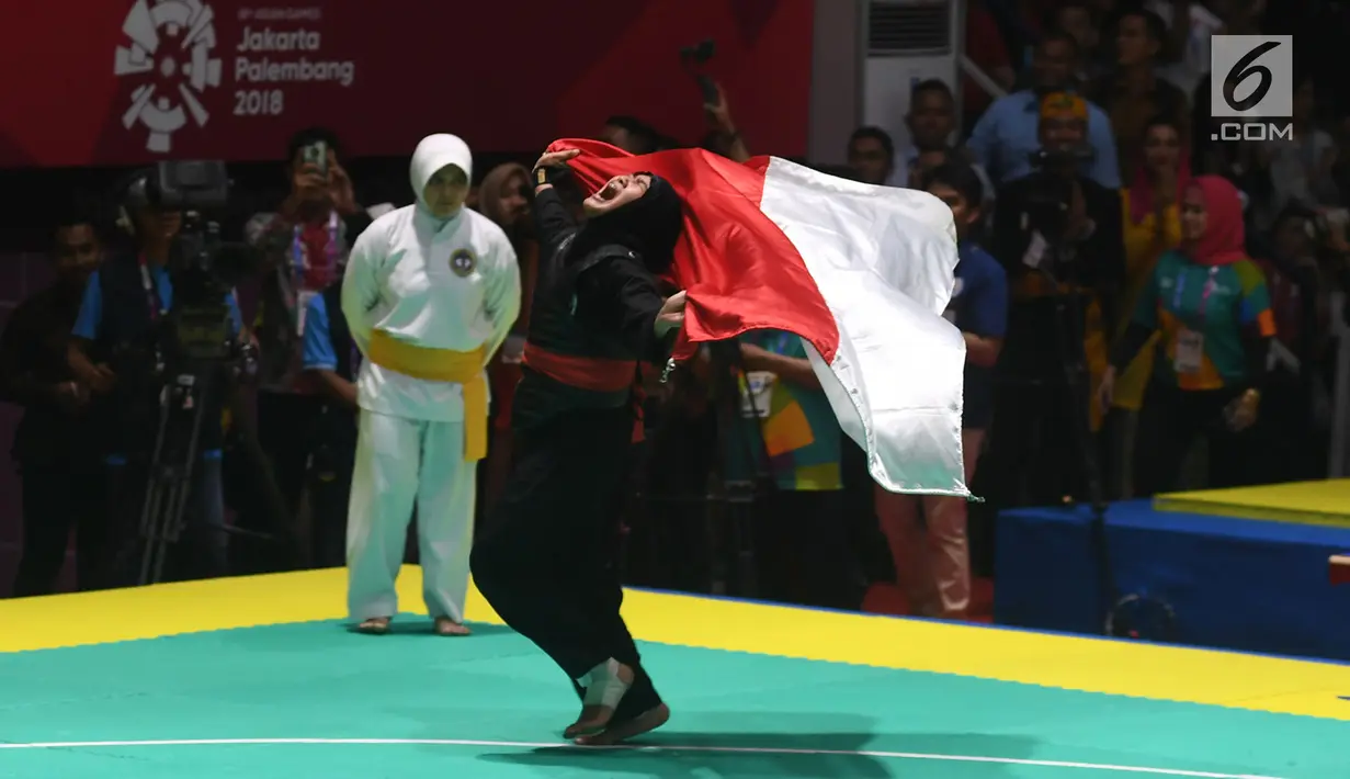 Pesilat Indonesia Pipiet Kamelia berselebrasi membawa bendera Merah Putih usai mengalahkan Thi Cam Nhi Nguyen dari Vietnam pada final nomor 60-65 kg putri pencak silat Asian Games 2018, Jakarta, Rabu (29/8). (Merdeka.com/Imam Buhori)