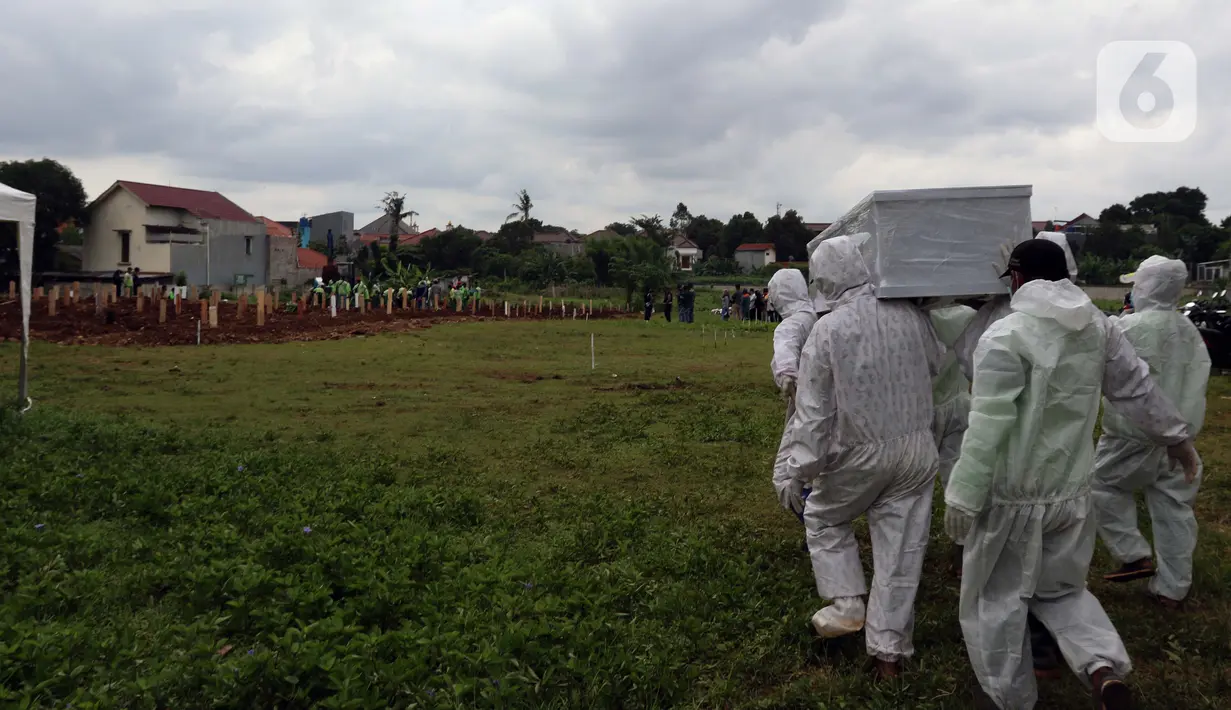 Petugas membawa peti jenazah yang akan dimakamkan dengan protokol COVID-19 di area khusus TPU Srengseng Sawah, Jakarta, Kamis (14/1/2021). TPU ini digunakan untuk memakamkan jenazah dengan protokol COVID-19 karena TPU Tegal Alur dan Pondok Ranggon sudah penuh. (Liputan6.com/Helmi Fithriansyah)